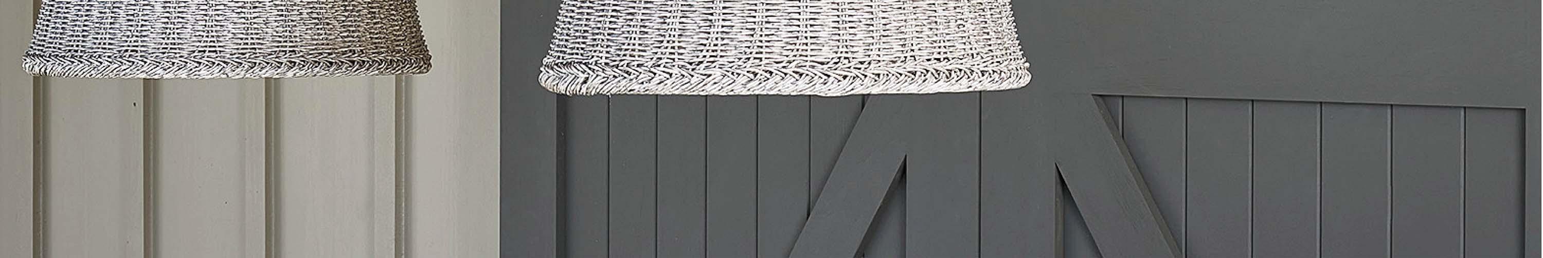 Two wicker outdoor ceiling lights in front of a gray barn door